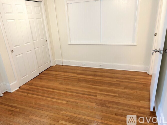A room with wooden flooring and white walls.