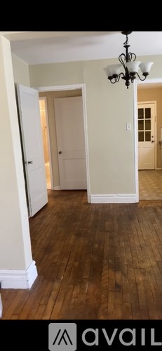 A room with wooden floors and a chandelier.