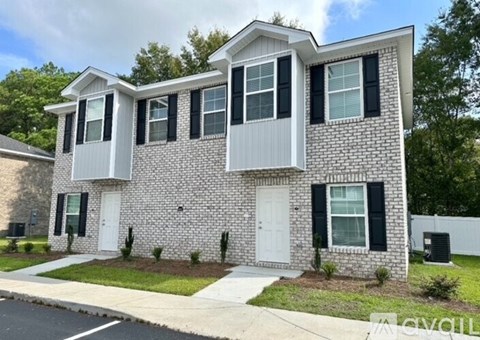 A two-story house with a white door and black shutters.