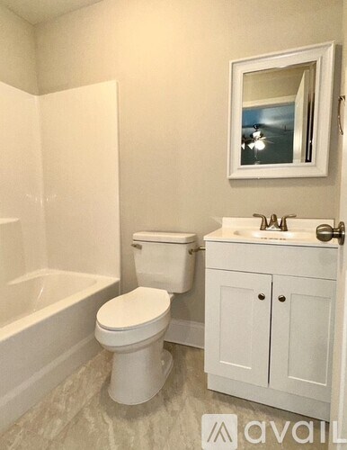 A white toilet sits next to a white sink in a bathroom.