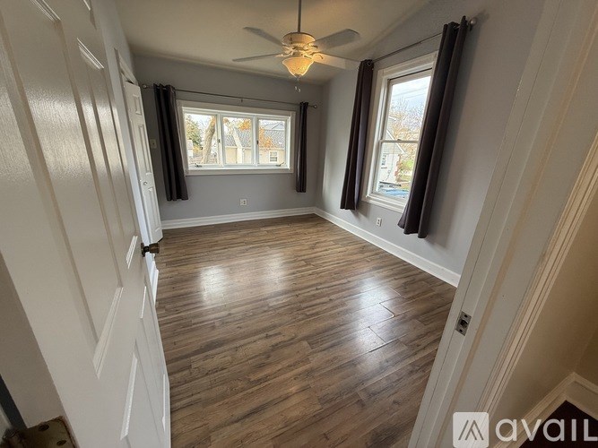 A room with wooden flooring and a ceiling fan.