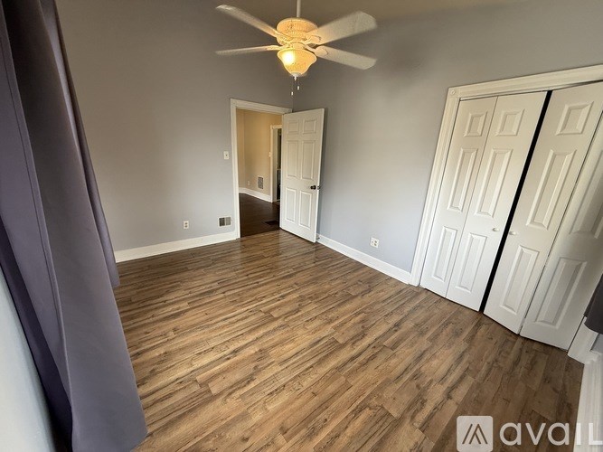 A room with wooden flooring and a ceiling fan.