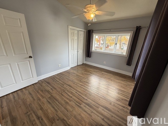 A room with wooden flooring and a ceiling fan.