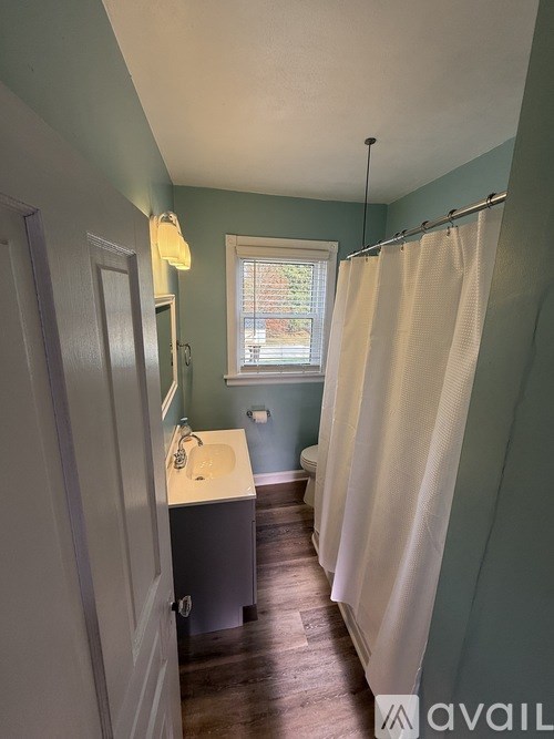 A bathroom with a window and a sink.