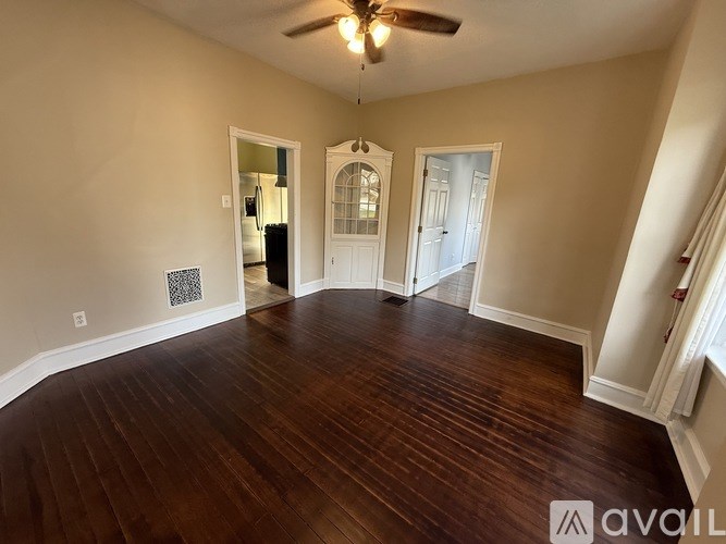 A room with wooden floors and a ceiling fan.