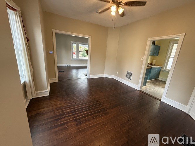 A room with wooden floors and a ceiling fan.