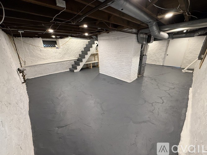 A spacious basement with a concrete floor and a staircase leading to the upper level.