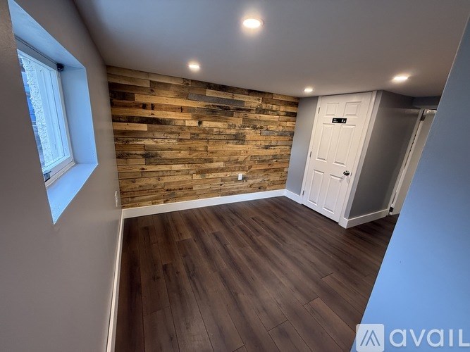 A room with wooden walls and a white door.