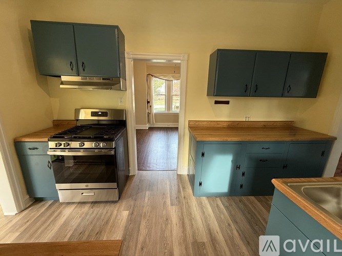 A kitchen with a stove, cabinets, and a sink.