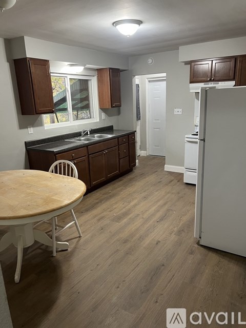 A kitchen with wooden floors and white appliances.