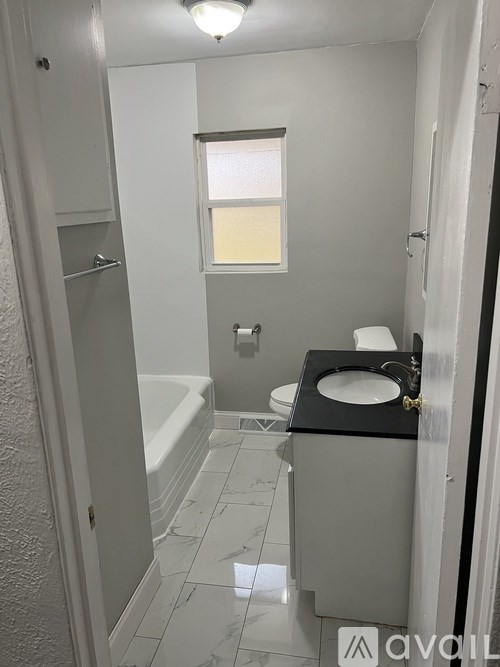 A bathroom with a toilet, sink, and bathtub.