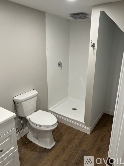 A white toilet in a small bathroom with a walk-in shower.