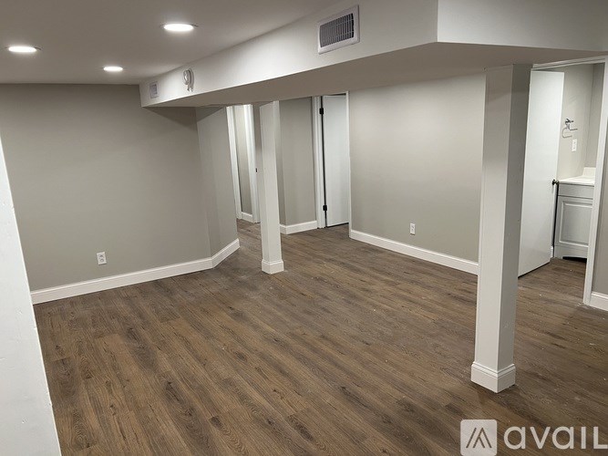 A room with wooden flooring and white walls.