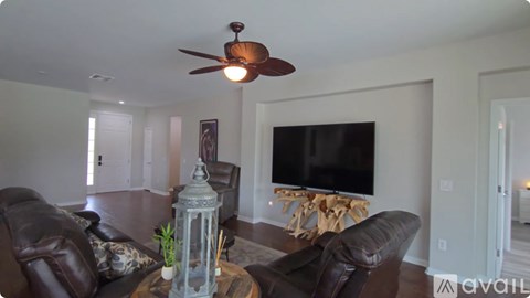 A living room with a brown leather couch and a television.
