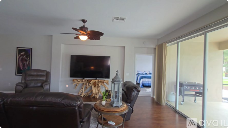 A living room with a brown leather couch, a wooden coffee table, and a ceiling fan.