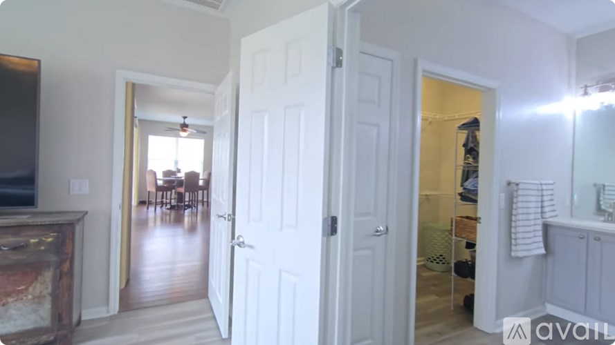 A hallway with a white door on the left and a mirror on the right.