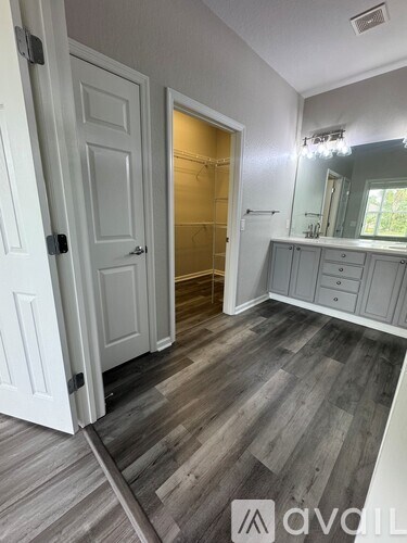 A room with a white door and a grey floor.