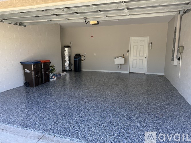 A spacious garage with a white door and a grey floor.