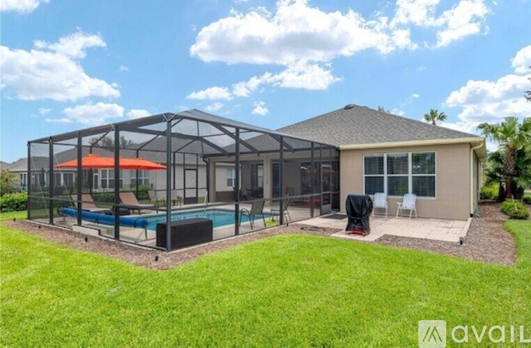 A house with a pool and a sunroom attached to it.