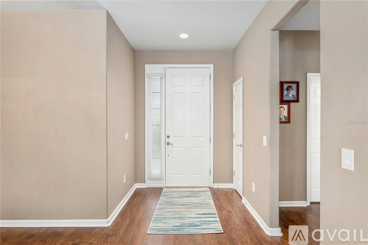A hallway with a white door and a framed picture on the wall.