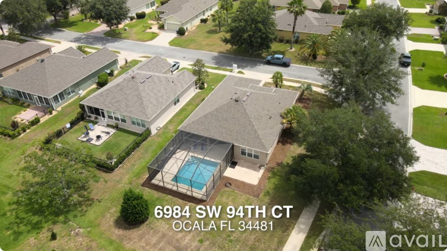 A bird's eye view of a residential area with houses and a swimming pool.