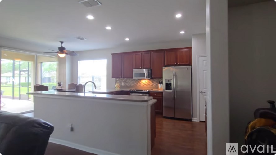 A kitchen with a refrigerator, sink, and cabinets.