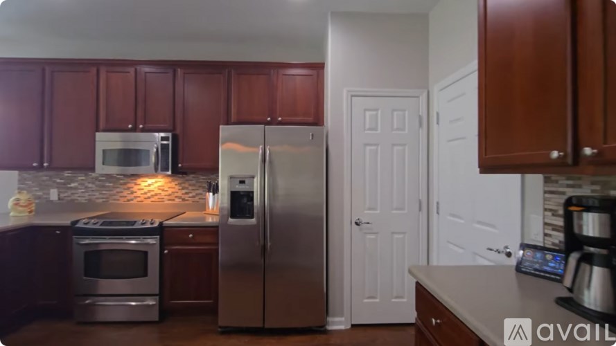 A kitchen with brown cabinets and a stainless steel refrigerator.