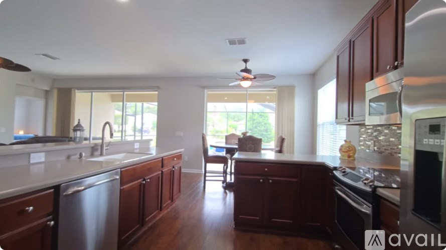 A kitchen with dark wood cabinets and stainless steel appliances.