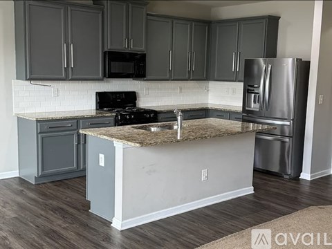 A kitchen with a granite countertop and stainless steel appliances.