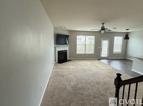A living room with a television, fireplace, and a ceiling fan.
