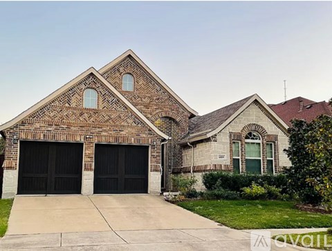 A house with a brick facade and two garage doors.