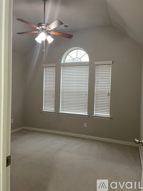 A room with a ceiling fan and a window with blinds.