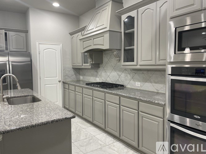 A modern kitchen with granite countertops and stainless steel appliances.