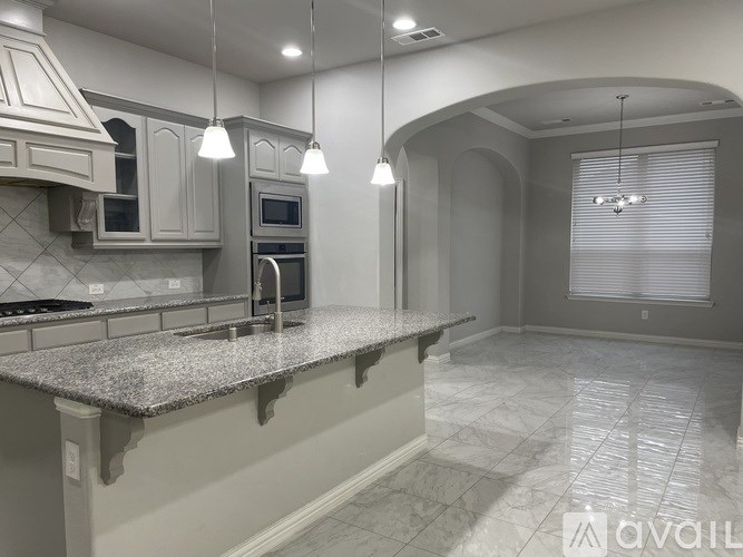 A kitchen with granite countertops and a stainless steel oven.