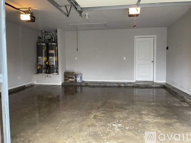 A room with a white door and a concrete floor.