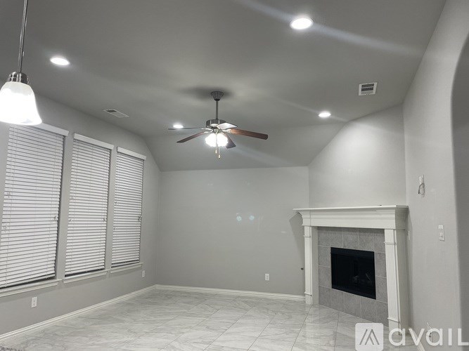 A living room with a fireplace and a ceiling fan.