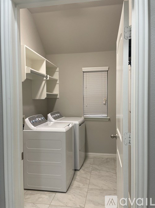 A small, white, enclosed room with a washing machine and dryer.