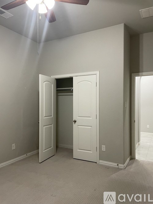 A room with a ceiling fan and two doors.