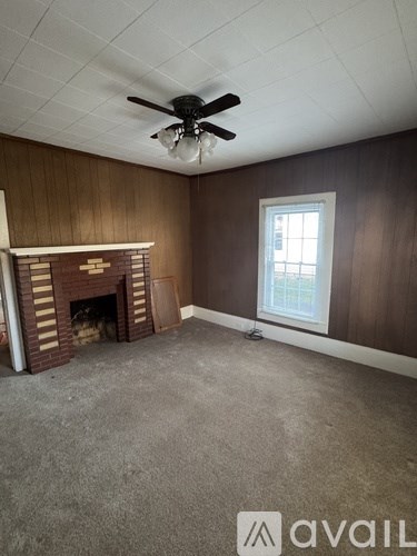 A room with a fireplace and a window.