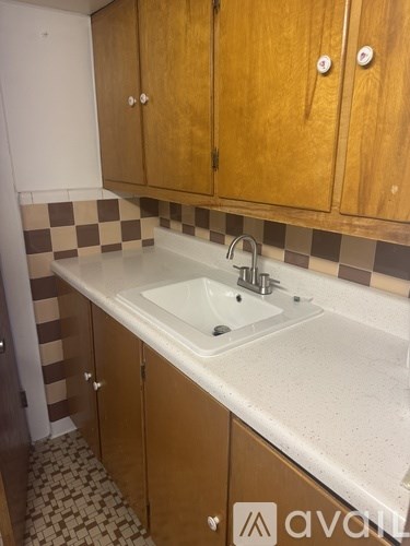 A bathroom with brown cabinets and a checkered floor.