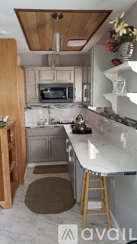 A kitchen with a white counter top and wooden cabinets.