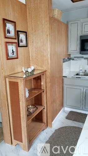 A kitchen with a wooden cabinet and a microwave above the stove.
