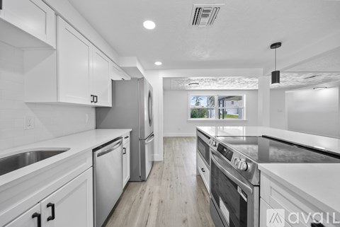 A modern kitchen with white cabinets and stainless steel appliances.