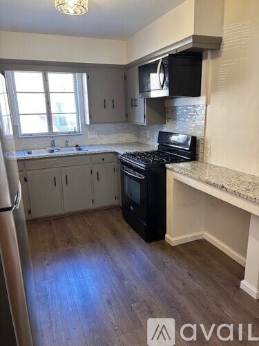 A kitchen with a black oven and white cabinets.