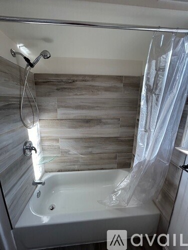 A bathroom with a white tub and a shower curtain.