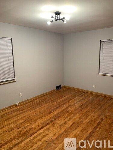 A room with wooden flooring and a ceiling fan.