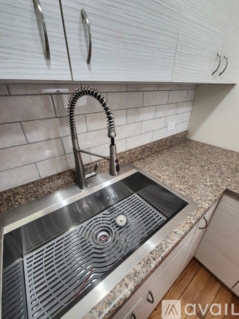 A modern kitchen sink with a chrome faucet and a granite countertop.