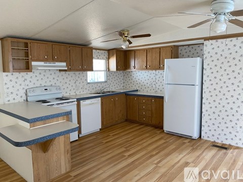 A kitchen with wooden cabinets and a white fridge.