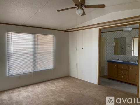 A room with a ceiling fan and a large mirror.