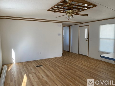 A room with wooden flooring and a ceiling fan.
